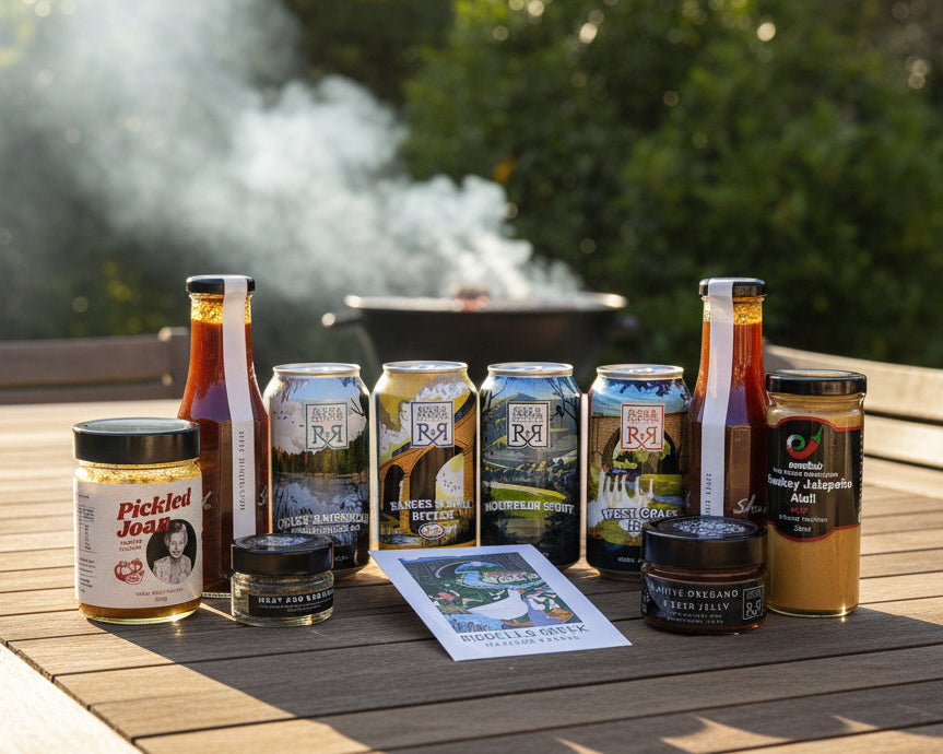 the contents of a craft beer and bbq condiments hamper including sauces from Beth Shan, Emelia's, Chintin Botanicals and Pickled Joan. All from the Macedon Ranges. 