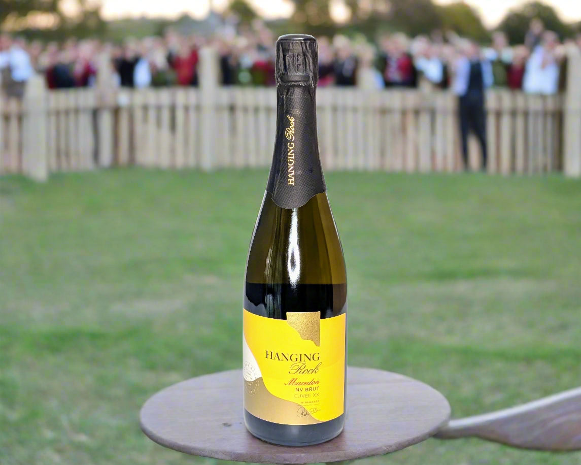 a bottle of Macedon Ranges NV Brut on an outdoor table at the races in Hanging Rock