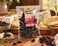 A clear plastic bag of 'The Macedon Rangers' MuscateLS on Vine dried grapes, showing the dark purple dried grapes inside and a kraft paper label, set against a plain white background.