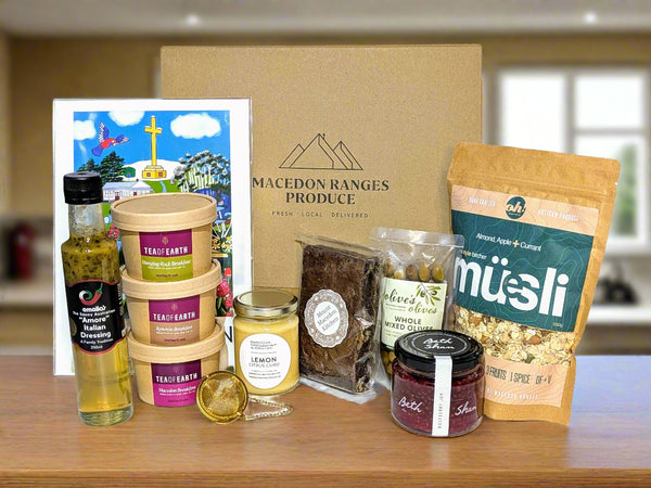Assorted groceries including a bottle, jars, and a package of müsli on a white background.