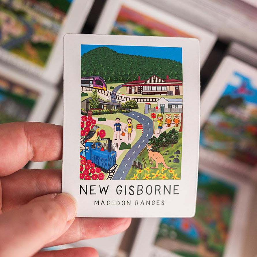 Card with a colorful illustration magnet of New Gisborne and a hand holding it.