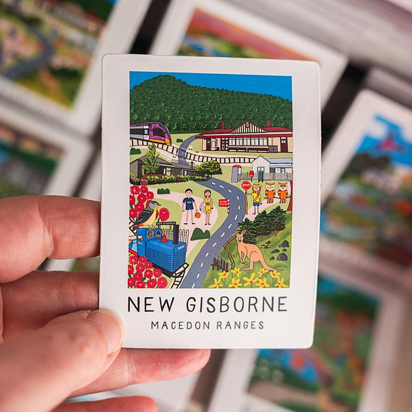 Card with a colorful illustration magnet of New Gisborne and a hand holding it.