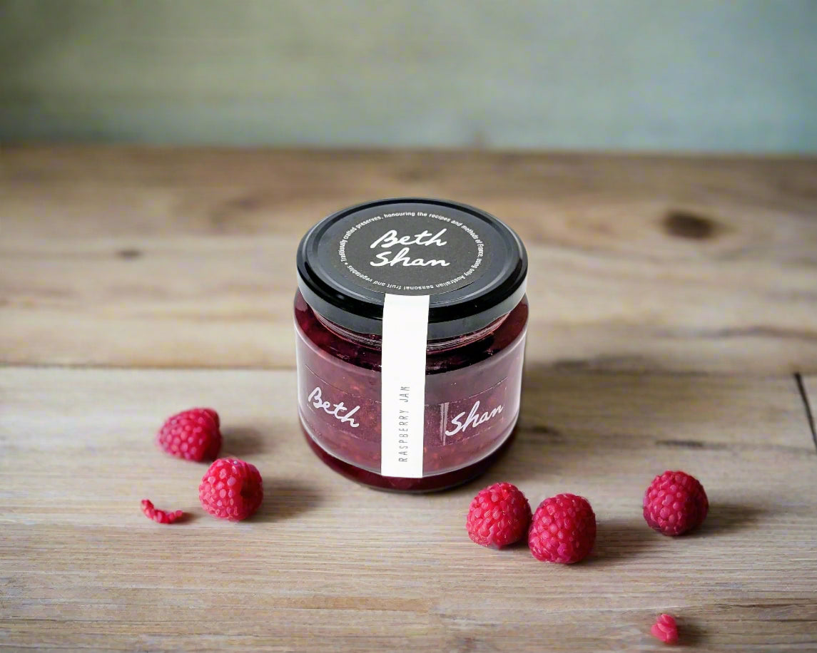 a jar of raspberry jam from the Macedon Ranges on a table with raspberries