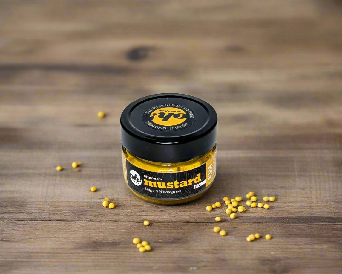 a jar of mustard made in the Macedon Ranges on table with some mustard seeds