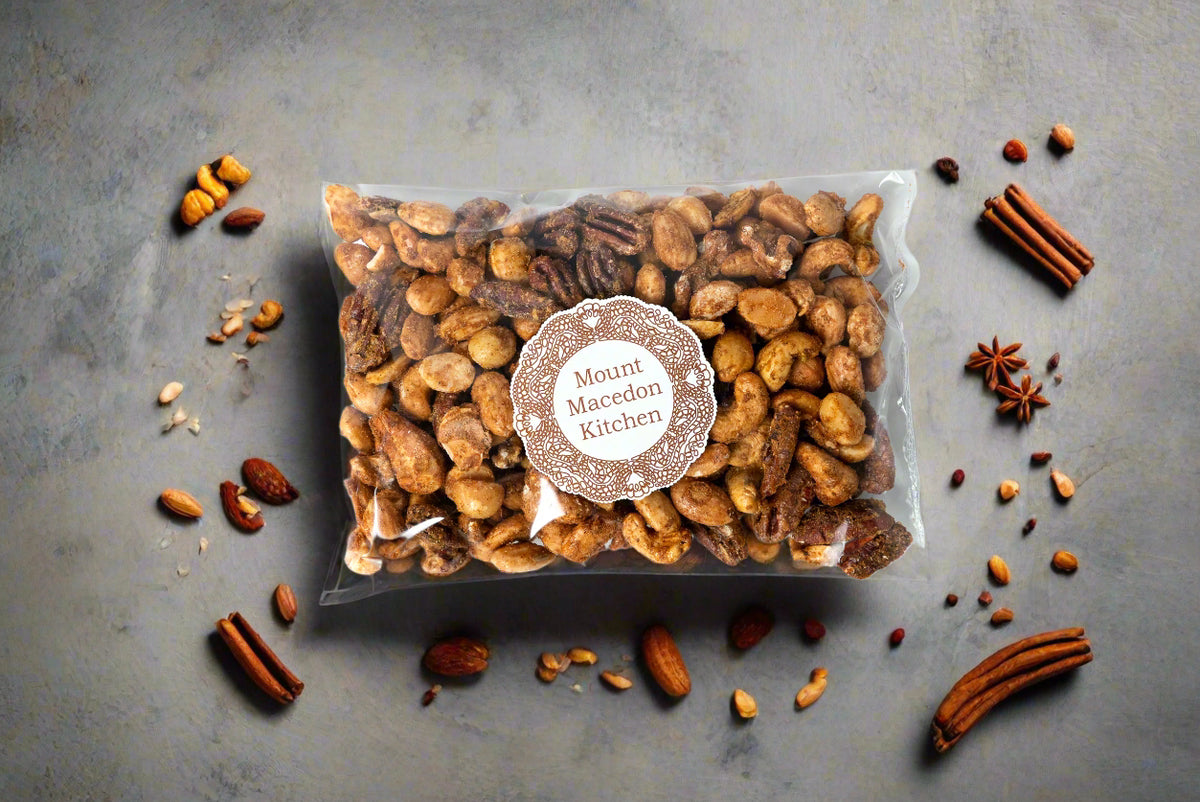 a bag of spiced nuts made in the Macedon Ranges on a bench surrounded by nuts and spices