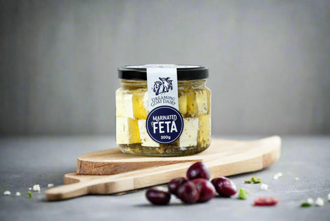 a jar of marinated feta from the Macedon Ranges on serving board with olives