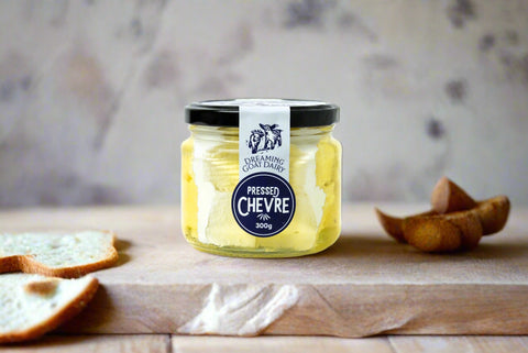 a jar of pressed chevre or goats cheese from the Macedon Ranges on a serving board with bread