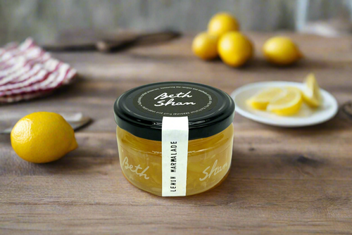 a jar of lemon marmalade made in the Macedon Ranges sitting on kitchen table with lemons