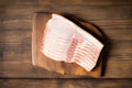 Bacon from the Macedon Ranges on a wooden chopping board ready for breakfast