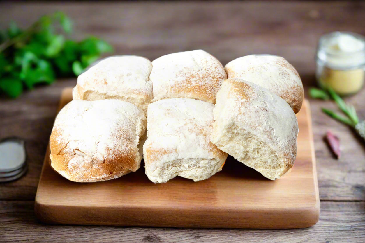 six fresh white bread rolls covered in flour on a bread board in the Macedon Ranges